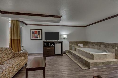 ein großes Wohnzimmer mit Badewanne und Sofa in der Unterkunft Park Inn by Radisson Salt Lake City -Midvale in Midvale