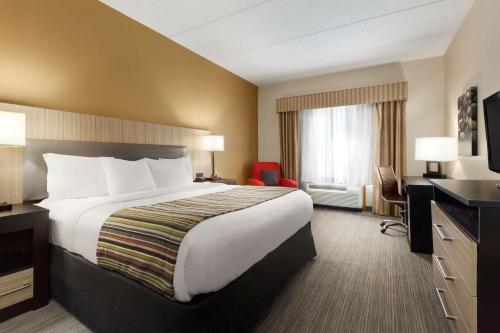 a hotel room with a large bed and a television at Country Inn & Suites by Radisson, Dalton, GA in Dalton