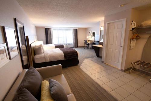 a hotel room with a bed and a couch at Country Inn & Suites by Radisson, Decorah, IA in Decorah