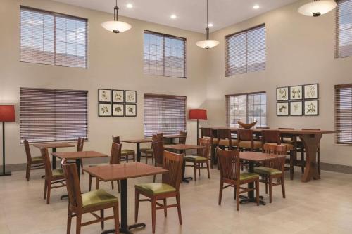 a dining room with tables and chairs and windows at Country Inn & Suites by Radisson, London, KY in London