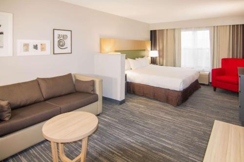 a hotel room with a bed and a couch at Country Inn & Suites by Radisson, Stockton, IL in Stockton