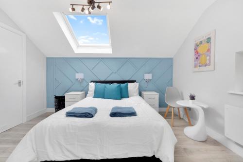 a bedroom with a large bed with a blue wall at Waterside 4 Bed Apartment in London