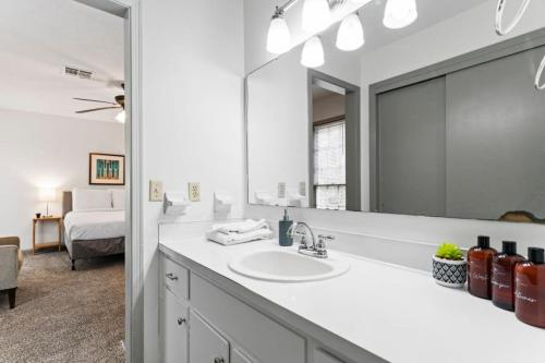 a white bathroom with a sink and a mirror at Midtown Fenced Yard & Patio- White Acres Retreat in Montgomery