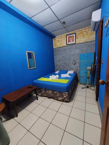 a blue room with a bed and a table at D' all leon hostal in León