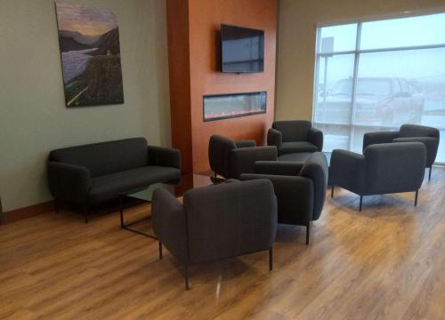 uma sala de espera com sofás e cadeiras e uma televisão em Radisson Hotel Pendleton Airport em Pendleton