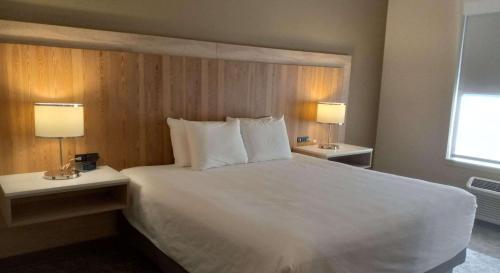 a bedroom with a large white bed with two lamps at Radisson Hotel Pendleton Airport in Pendleton