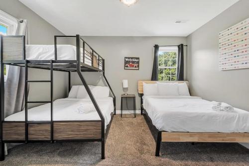 a bedroom with two bunk beds and a window at Mins to Oakwood U! American Retreat in Huntsville