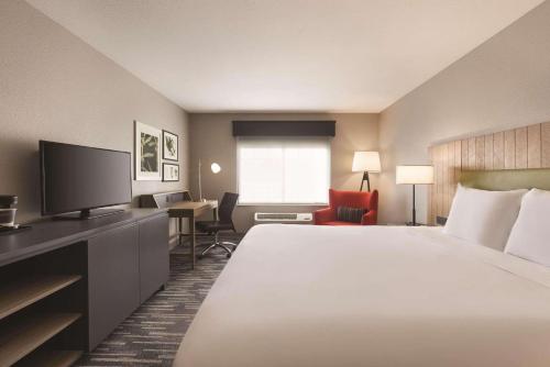 a hotel room with a large bed and a television at Country Inn & Suites by Radisson, Green Bay North in Green Bay