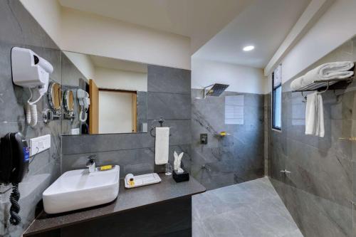 y baño con lavabo y ducha. en Comfort Inn Sapphire, Chandkheda, en Adalaj