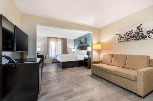 a hotel room with a bed and a couch at Sleep Inn & Suites in Newport News
