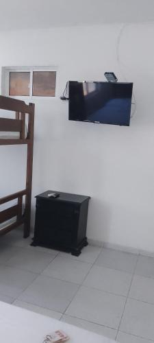 Habitación blanca con TV y silla en Hotel Río Mar, en Cartagena de Indias