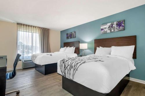 a hotel room with two beds and a window at Sleep Inn & Suites in Newport News