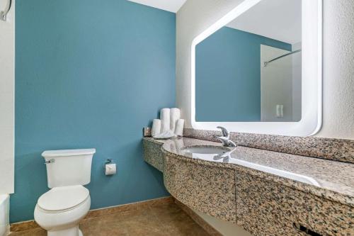 y baño con aseo y lavabo con espejo. en Sleep Inn & Suites, en Newport News