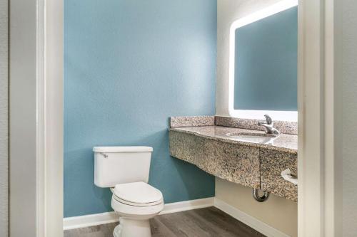 a bathroom with a white toilet and a sink at Sleep Inn & Suites in Newport News