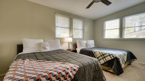 a bedroom with two beds and two windows at Halcyon Hangout-Mins to Downtown-Ping Pong-Pets in Savannah