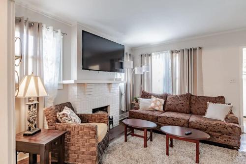 a living room with a couch and a fireplace at Haute on Hannon- Midtown Cottage! in Mobile