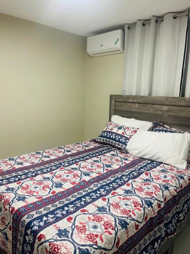 a bedroom with a bed with a colorful comforter at New Kingston Paradise in Kingston