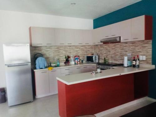 eine Küche mit weißen Schränken und einem weißen Kühlschrank in der Unterkunft Casa Mandala Reload Cuerna in Cuernavaca