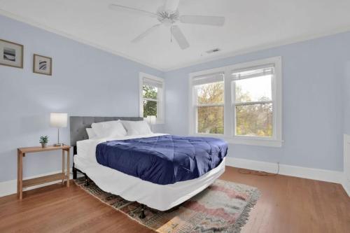 a white bedroom with a bed and two windows at Crafty in Haymount- Mins to Downtown Fayetteville! in Fayetteville