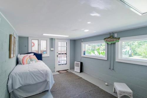 a bedroom with a bed and two windows at Dozing on Dog River- River Access Dock Yard in Tillmans Corner