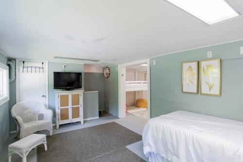a bedroom with a bed and a tv in it at Dozing on Dog River- River Access Dock Yard in Tillmans Corner