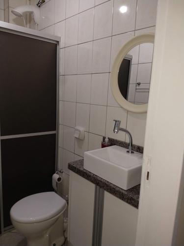 y baño con aseo, lavabo y espejo. en Murilo House en São José