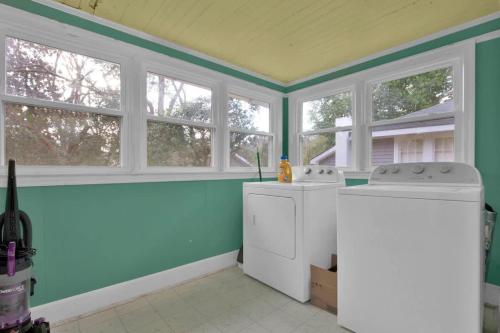 a kitchen with a washer and dryer and three windows at Crafty in Haymount- Mins to Downtown Fayetteville! in Fayetteville