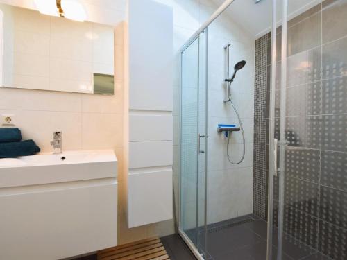 a bathroom with a shower and a sink at Zon en Zee in Kattendijke