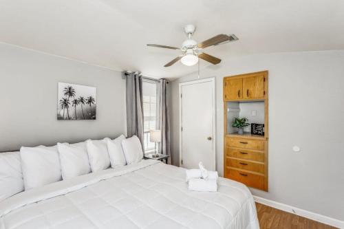- une chambre avec un lit blanc et un ventilateur de plafond dans l'établissement North Highlands Nest- Unit D, à Pensacola