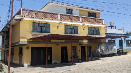 a yellow building with windows on a street at Apartment in Colonia Molina in Quetzaltenango