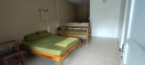 um quarto com duas camas e um sofá em Scar Reef Homestay em Jereweh