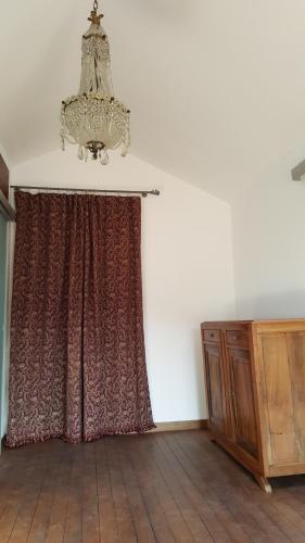Cette chambre comprend un rideau et un lustre. dans l'établissement Appartement Corse Extrême-Sud, à Monacia-dʼAullène