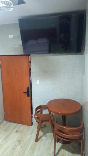 a wooden table and chair next to a door at Hospedaje Mi Casita - Pucallpa -Selva in Puerto Callao