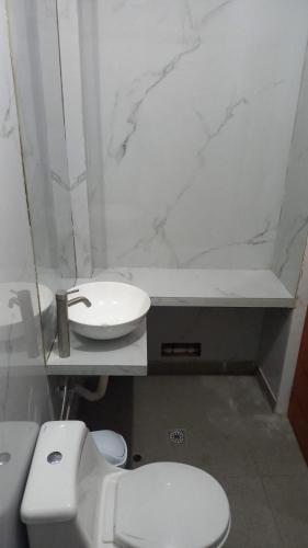 a white bathroom with a sink and a toilet at Hospedaje Mi Casita - Pucallpa -Selva in Puerto Callao