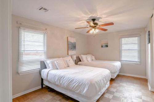 a bedroom with two beds and a ceiling fan at Enchanting Forestwood Retreat in Mobile