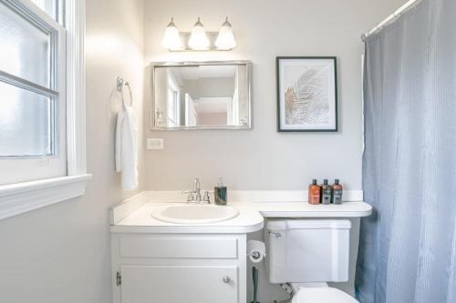 bagno con lavandino, servizi igienici e specchio di Enchanting Forestwood Retreat a Mobile