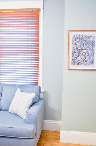 a blue couch in a room with a window at Modern & Centrally Located Stay at Calypso Dreams in Mobile
