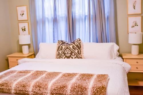 a bedroom with a large white bed with two night stands at Modern & Centrally Located Stay at Calypso Dreams in Mobile
