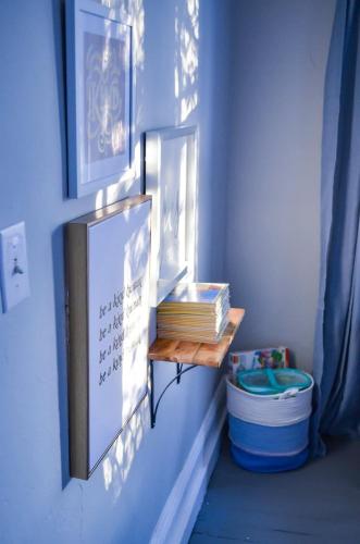 a shelf on a wall with books on it at Modern & Centrally Located Stay at Calypso Dreams in Mobile