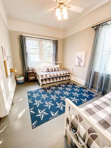 a bedroom with two beds and a blue rug at Modern & Centrally Located Stay at Calypso Dreams in Mobile
