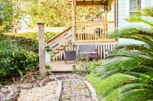 a house with a wooden porch with a chair on a patio at Modern & Centrally Located Stay at Calypso Dreams in Mobile