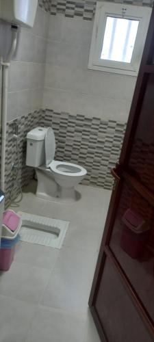 a bathroom with a toilet and a window at جراند روزالينا جازان in Bakhshat Yamanī