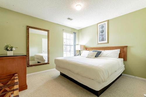 a bedroom with a large bed and a mirror at Aerie Oaks Cottage-5min to Lake, 20min to Columbia in Lexington