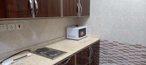 eine Mikrowelle auf einer Theke in einer Küche in der Unterkunft جراند روزالينا جازان in Bakhshat Yamanī