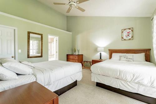 1 dormitorio con 2 camas, mesa y espejo en Aerie Oaks Cottage-5min to Lake, 20min to Columbia, en Lexington