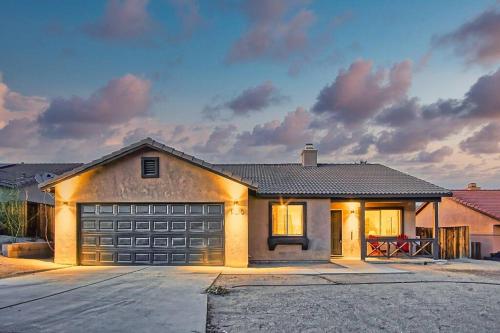 a house with a garage door in a driveway at Nightsky Nest ※ Desert Getaway by Joshua Tree Park in Twentynine Palms