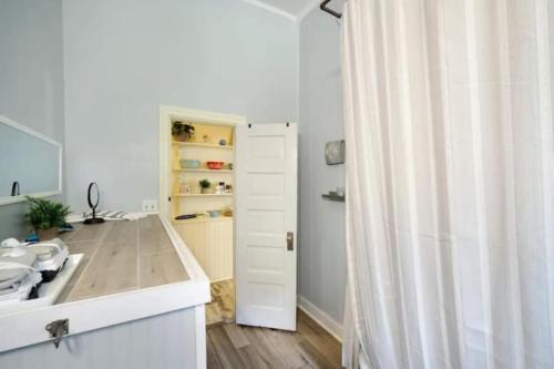 a white bathroom with a sink and a shower at The Mardis Gras Manor Walkable, Historic, Local Treasure in Mobile