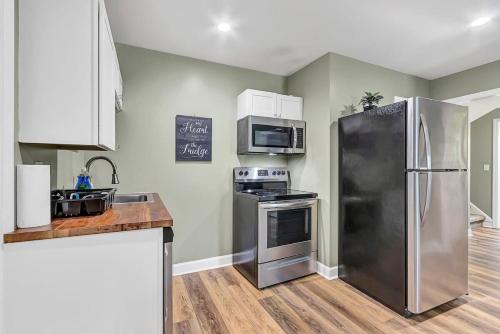 a kitchen with a stainless steel refrigerator and microwave at Mins to Downtown - Huntsville Oasis in Huntsville