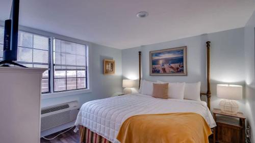een slaapkamer met een groot bed en 2 ramen bij Flamingle in Fushia- Unit B- Steps to the Beach! in Tybee Island