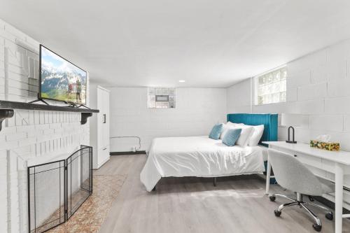 una camera da letto bianca con un letto e una scrivania di Cozy Speedway Basement a Indianapolis